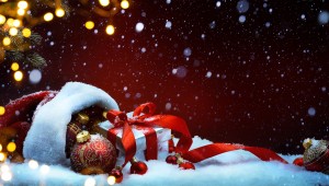 Christmas tree light; festive background with Christmas balls and gift box on snow